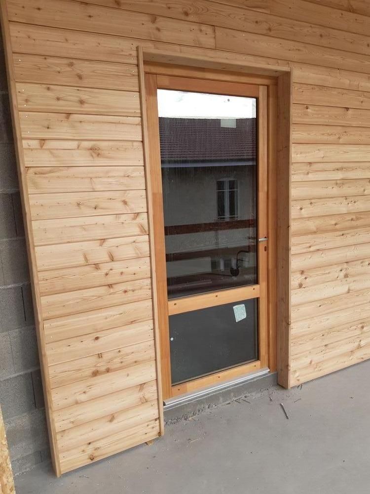 Porte-fenêtre vitrée sur façade bois